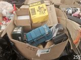 une boîte remplie d'objets hétéroclites posée sur le sol