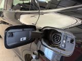 a close up of a car with an electric charger plugged into it