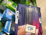 a person holding a bag of diapers in a shopping cart
