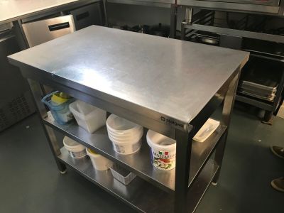 a stainless steel table with buckets on it in a commercial kitchen