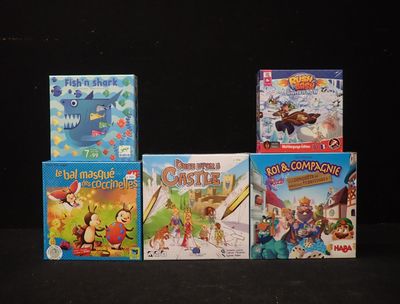Plusieurs jeux de société pour enfants sont alignés sur une surface noire