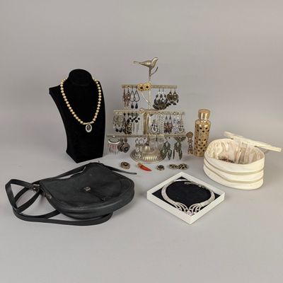 a black purse, a necklace, and other items on a table