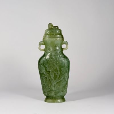un vase en verre vert orné d'un oiseau et dont le couvercle est également décoré d'un oiseau