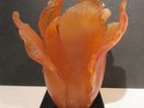 a glass vase with a flower inside of it on a stand