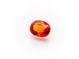 an oval shaped orange sapphire stone on a white background