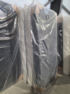 de nombreux matelas emballés dans du plastique dans un entrepôt