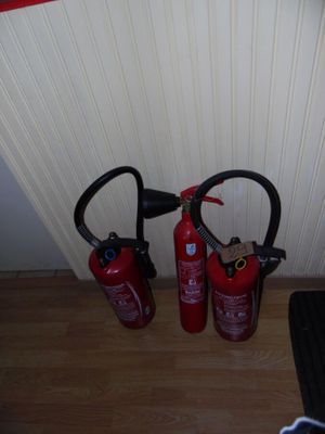 two fire extinguisors sitting next to each other on the floor