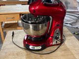 un mixeur rouge posé sur une table en bois