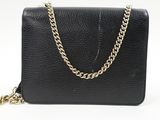 a black leather purse with gold chain on a white background