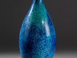un vase bleu et vert posé sur une table