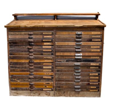 une vieille armoire en bois comportant de nombreux tiroirs et surmontée d'autres tiroirs