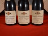 three bottles of wine sitting on a red cloth