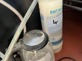 a bottle of liquid and a hose on the floor