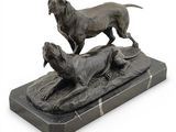 statue en bronze représentant deux chiens sur un socle en marbre, sur fond blanc