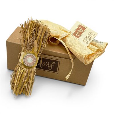 a bundle of straw tied to a box with a watch on it