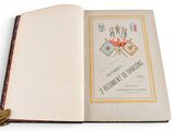 an open book with a tassel on top of it sitting on a table