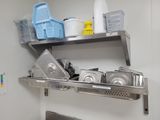 a metal shelf with dishes and pans on it