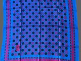 a blue and pink square scarf with black dots on it