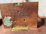 une photo d'une boîte en bois sur laquelle est posée une feuille