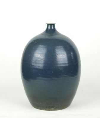 a blue vase that is sitting on a white surface