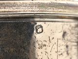 a close up of a silver plate with a black background