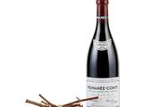 a bottle of red wine next to a bunch of sticks