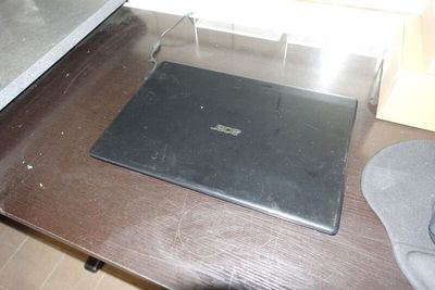 un ordinateur portable posé sur une table en bois
