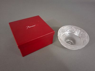 un saladier en verre et une boîte rouge posés sur une table