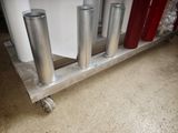 quatre cylindres métalliques posés sur un chariot dans une pièce