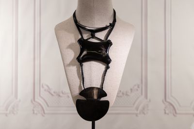 a mannequin with a necklace on it on a stand
