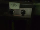 un poêle sur lequel est accrochée une pancarte, dans une pièce sombre