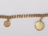 a close up of a gold bracelet with two coins on it