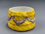 un gros plan d'une tasse jaune ornée d'une pieuvre