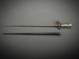 an old sword and a needle on a gray surface