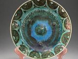 a blue and green plate with a bird design on it