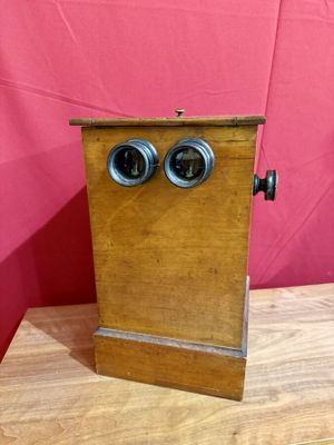 une vieille boîte en bois avec deux yeux, posée sur une table en bois