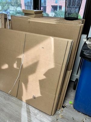 une pile de cartons posée par terre près d'une fenêtre