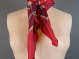 red scarf on a mannequin head with a red and white striped scarf