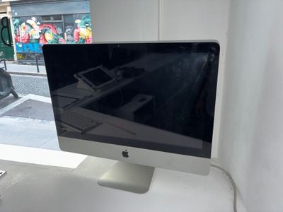 un écran d'ordinateur posé sur un bureau blanc