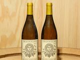 deux bouteilles de vin posées sur un tonneau