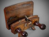 an old wooden plane with two wooden handles and a wooden case