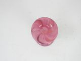 pink swirly glass knob with a white base on a white surface