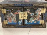 a black box with a painting on it sitting on the floor