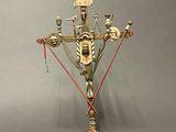a gold and red candle holder with a bird on top of it
