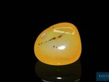 a yellow piece of glass sitting on top of a black surface