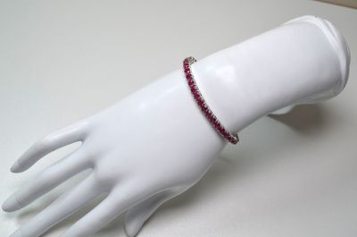 a white mannequin hand with a red bracelet on it