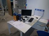 un bureau sur lequel se trouvent un ordinateur, un clavier, une souris et un agenda