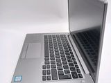 a silver laptop with a blue sticker on it