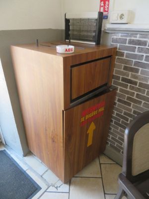 une armoire en bois sur laquelle est posé un micro-ondes, à côté d'une chaise