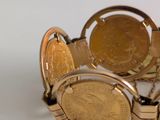 a gold bracelet with a coin on it and a watch on it
